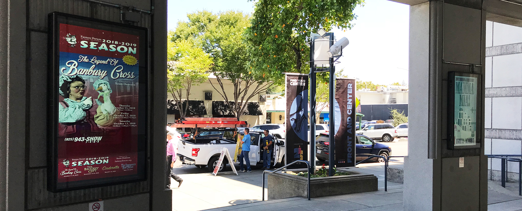 Two vertical digital signs on a pillar inside the Lesher Center for the Arts.